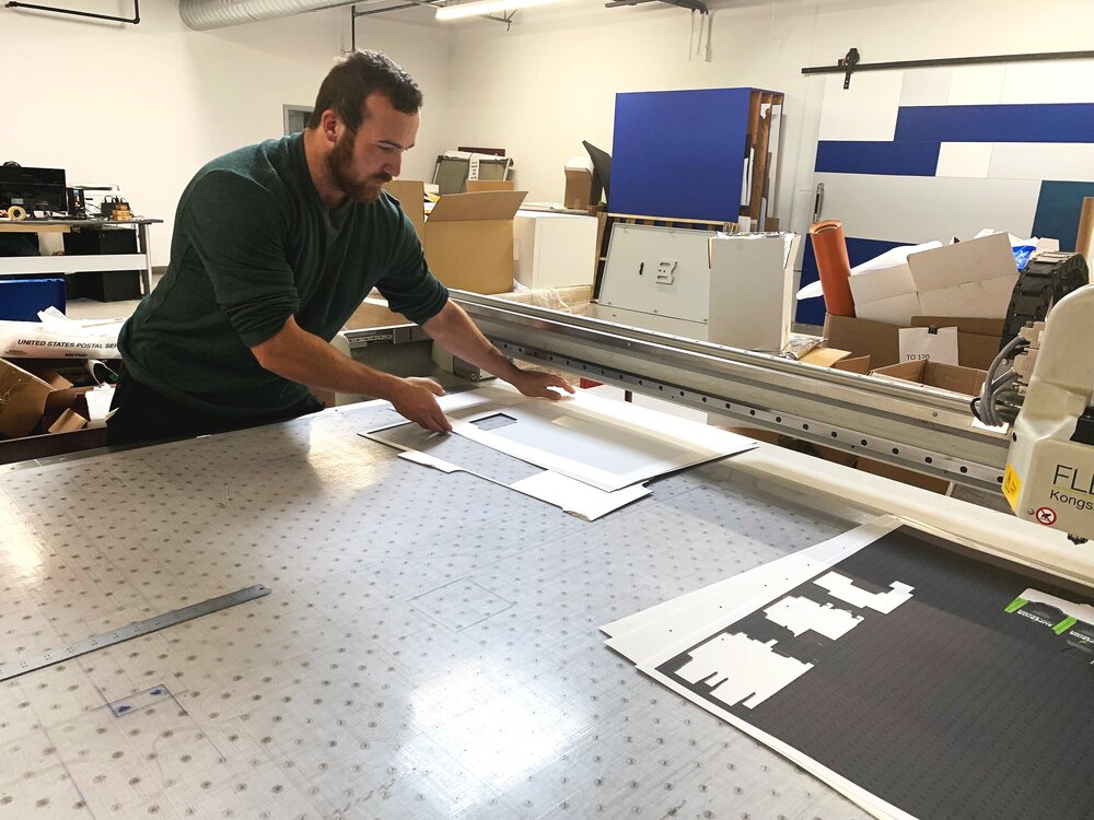 Person at CAD cutting machine with packaging on the table